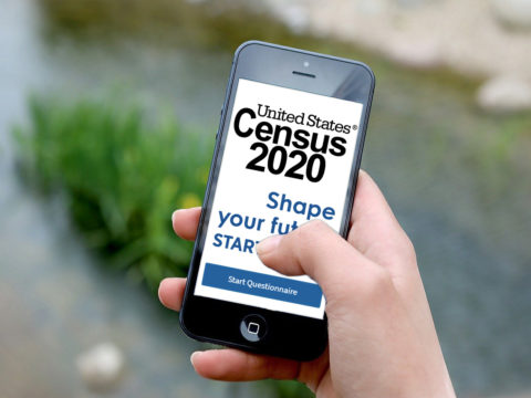 A person holding an iphone, getting ready to take the U.S. Census in 2020.